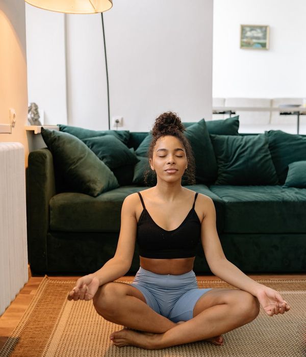 Woman in a serene yoga pose, ruby background.